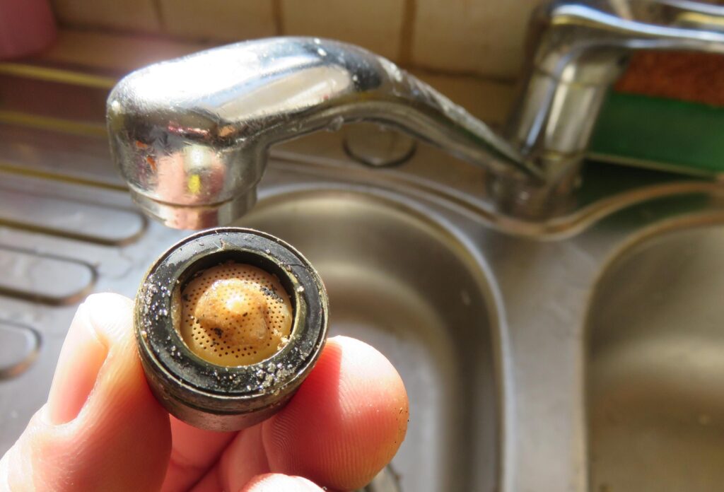 Persona por limpiar el filtro de un grifo